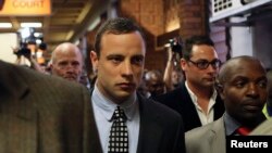 Oscar Pistorius (tengah) meninggalkan ruang sidang pengadilan di kota Pretoria, Afrika Selatan (4/6).