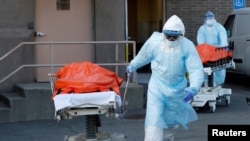 နယူးယောက်တွင် ကိုရိုနာဗိုင်းရပ်စ်ကြောင့် သေဆုံးသူများကို သယ်လာသည့် ကျန်းမာရေးဝန်ထမ်းများ။ (ဧပြီ ၄၊ ၂၀၂၀)