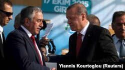 Presiden Turki Tayyip Erdogan (kanan) bersalaman dengan pemimpin Turki Siprus Mustafa Akinci dalam sebuah upacara peresmian proyek pipa air di Myrtoy, 17 Oktober 2015. 