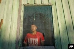 Pure Juma, son of Borea Juma, stand inside his house at the Juma Indigenous community, near Canutama, Amazonas state, Brazil, Sunday, July 9, 2023. (AP Photo/Andre Penner)