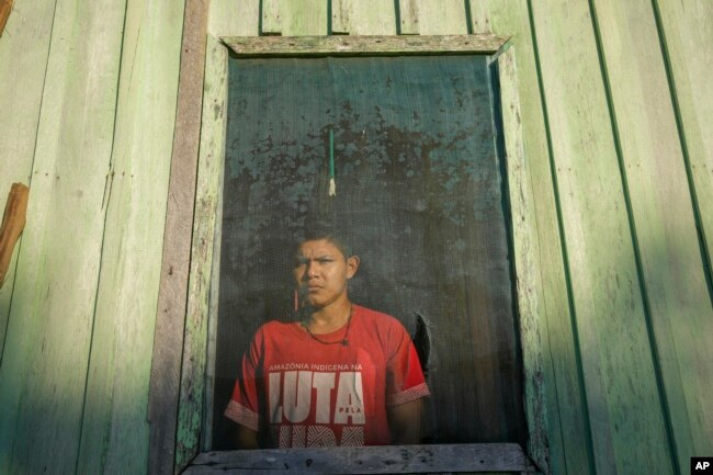 Pure Juma, son of Borea Juma, stand inside his house at the Juma Indigenous community, near Canutama, Amazonas state, Brazil, Sunday, July 9, 2023. (AP Photo/Andre Penner)