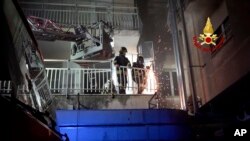 Firefighters work on the balcony of a building of the St. John the Evangelist Hospital after a fire broke out causing the death of three people in Tivoli, Italy, on Dec. 8, 2023.