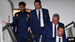 Pemain depan tim Brazil, Neymar (kiri) dan pelatih Tite (kedua dari kanan), turun dari pesawat saat tiba di Bandara Sochi, Rusia, 11 Juni 2018.