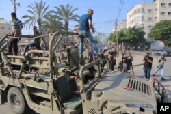 Palestinci se voze na izraelskom vojnom vozilu.