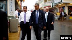 ປະທາ​ນາ​ທິບໍດີ Barack Obama ແລະ ທ່ານ Chris Christie ຜູ້ປົກຄອງລັດ New Jersey ທ່ຽວຊົມຫ້າງຮ້ານ, ຮ້ານອາຫານ ແລະຮ້ານຄ້າຕ່າງໆ ທີ່ໄດ້ເປີດຄືນອີກ ໃນວັນອັງຄານວານນີ້ ຢູ່ຕາມບໍລິ​ເວນທາງຍ່າງເລາະແຄມທະເລ ທີ່ເມືອງ Point Pleasant ຢູ່ລັດ New Jersey ໃນວັນທີ 28 ພຶດສະພາ, 2013. 