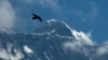 FILE - A bird flies as Mount Everest is seen from Namche Bajar, Solukhumbu district, Nepal, May 27, 2019.