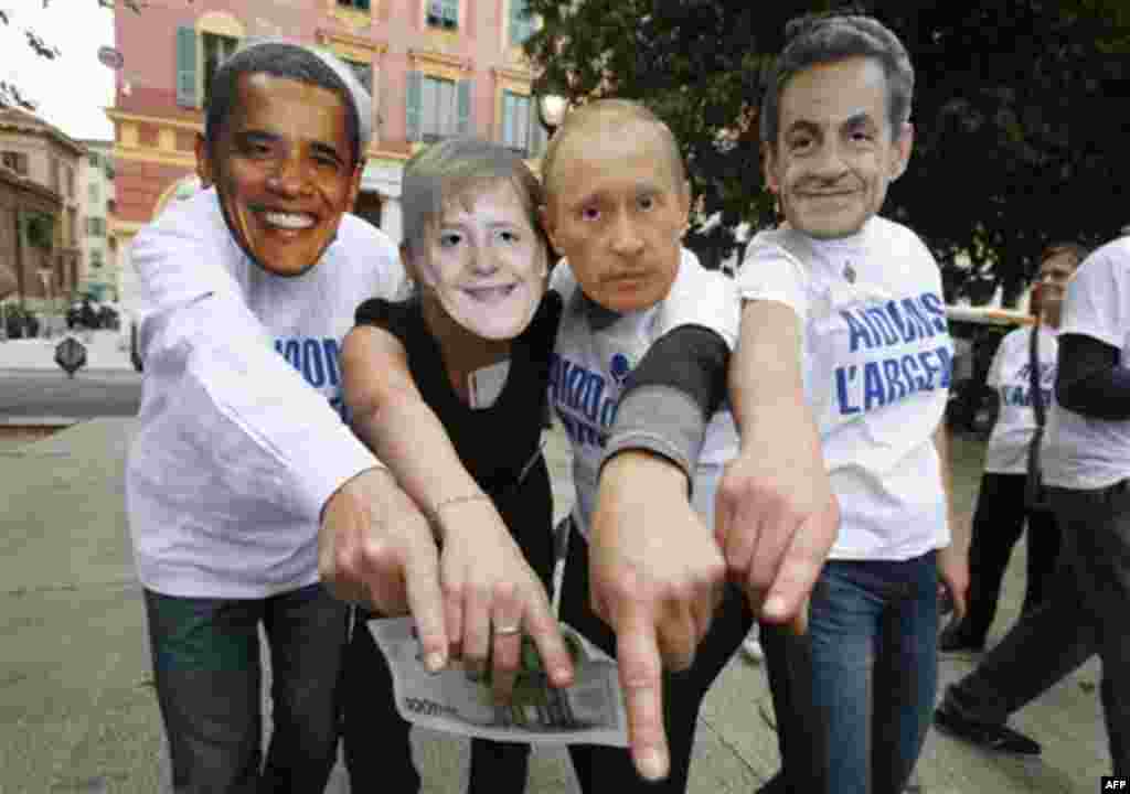 Anti-globalization members wearing masks, from left, of US President Barack Obama, German Chancellor Angela Merkel, Vladimir Putin Prime Minister of Russia and French President Nicolas Sarkozy demonstrate in Nice, southeastern France, against G20 summit 