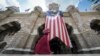 FILE - A Muslim woman walks past a Malaysian flag in front of Sultan Abdul Samad building at Independence Square in Kuala Lumpur, Malaysia.