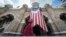 FILE - A Muslim woman walks past a Malaysian flag in front of Sultan Abdul Samad building at Independence Square in Kuala Lumpur, Malaysia.