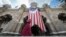 FILE - A Muslim woman walks past a Malaysian flag in front of Sultan Abdul Samad building at Independence Square in Kuala Lumpur, Malaysia.