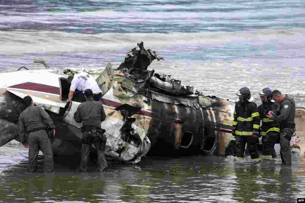 Rescue teams work after a private plane exploded and crashed into the Cruzeiro beach while attempting to take off from the Ubatuba airport, in Ubatuba, Sao Paulo state, Brazil. According to Ubatuba City Hall, one person is dead and four other were injured.