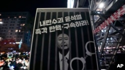 Una imagen muestra al presidente surcoreano Yoon Suk Yeol encarcelado con el texto: "Arresten e impugnen al líder rebelde Yoon Suk Yeol," se exhibe durante una manifestación frente a la Asamblea Nacional en Seúl, Corea del Sur, el 13 de diciembre de 2024.