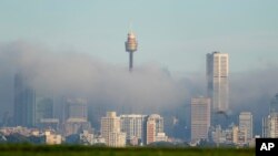 FILE - Fog drifts through the buildings in Sydney's central business district, Australia, June 11, 2021. 