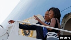 Presiden Amerika Barack Obama dan Ibu Negara Michelle Obama melambaikan tangan dari pesawat Air Force One di Pangkalan Udara Andrews dekat Washington, sebelum bertolak ke Afrika untuk lawatan selama seminggu (26/6). 