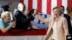 FILE - Democratic presidential candidate Hillary Clinton is greeted as she arrives at a campaign event at John Marshall High School in Cleveland, Aug. 17, 2016.