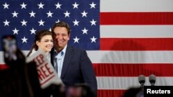 Le gouverneur de Floride Ron DeSantis monte sur scène aux côtés de sa femme Casey DeSantis lors d'un rassemblement avant les élections de mi-mandat, à Hialeah, Floride, le 7 novembre 2022.