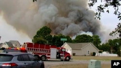 Crews work to contain a wildfire in the Carolina Forest area, west of the coastal resort city of Myrtle Beach, South Carolina, March 2, 2025. (WMBF-TV via AP)