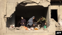 People look for salvageable items following an Israeli strike in Deir el-Balah in the central Gaza Strip on Dec. 22, 2024, amid the ongoing war between Israel and the Palestinian militant group Hamas. 