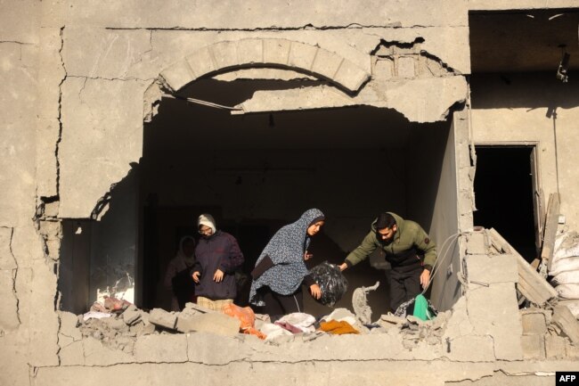 Orang-orang mencari barang-barang yang bisa diselamatkan setelah serangan Israel di Deir el-Balah di Jalur Gaza tengah pada 22 Desember 2024. (Foto: AFP)