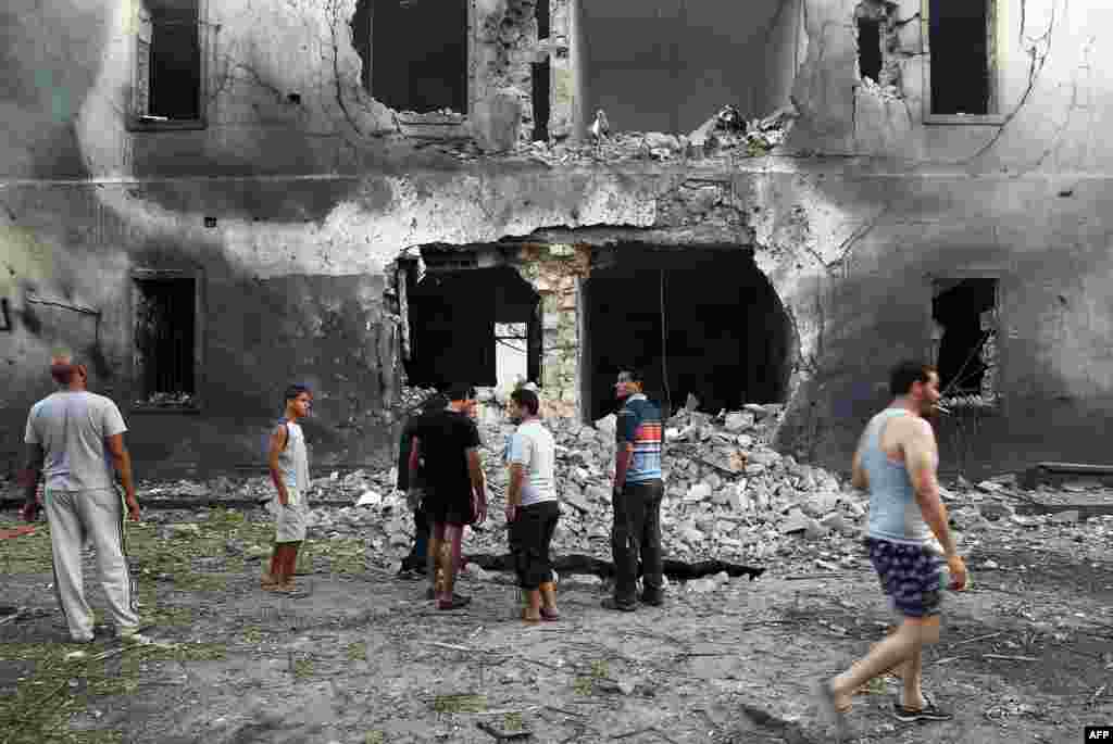 Libyans gather outside a foreign ministry building that was hit by a powerful blast in the eastern city of Benghazi.