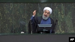 Iranian President Hassan Rouhani speaks in a session of the parliament in Tehran on August 28, 2018. Experts say Iran has a network of media providers aimed at spreading Iranian influence around the world. (AP Photo/Vahid Salemi)