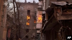 In this photo provided by the Ukrainian Emergency Services on Jan. 1, 2025, a residential building is seen damaged by a Russian drone strike in the city center of Kyiv, Ukraine.