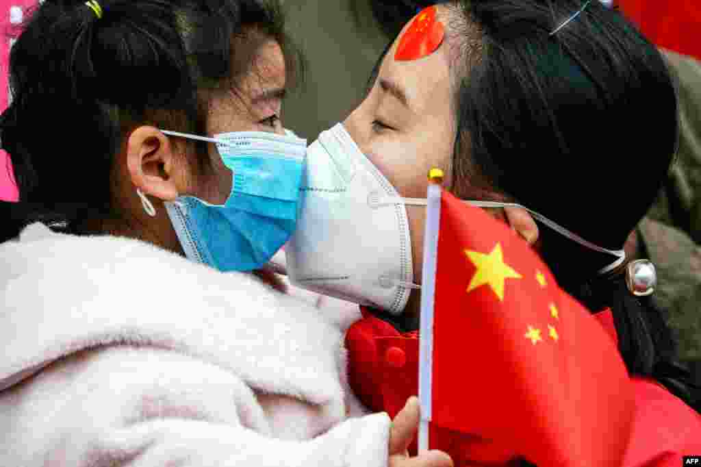 A medical staff member kisses her daughter after returning home from Wuhan helping with the COVID-19 coronavirus recovery effort, in Bozhou, in China's eastern Anhui province.