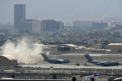 Tentara AS berdiri di landasan saat pesawat Angkatan Udara AS bersiap lepas landas dari bandara di Kabul pada 30 Agustus 2021. (Foto: AFP)