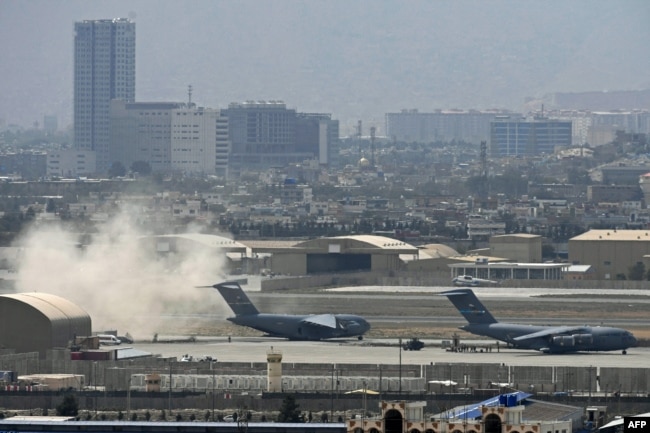 Tentara AS berdiri di landasan saat pesawat Angkatan Udara AS bersiap lepas landas dari bandara di Kabul pada 30 Agustus 2021. (Foto: AFP)