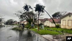 In this photo provided by the U.S. Coast Guard, downed tree branches litter a neighborhood in Yona, Guam, May 25, 2023, after Typhoon Mawar hit the island.