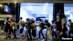 Les manifestants escortés hors du campus de l'Université polytechnique de Hong Kong (PolyU) après un affrontements avec la police à Hong Kong,