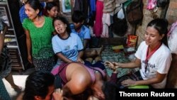 27일 미얀마 양곤에서 시위 도중 총격 사망한 시민을 붙잡고 가족들이 오열하고 있다.