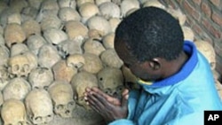 A Rwandan survivor of the 1994 genocide prays over the bones of genocide victims at a mass grave in Nyamata, Rwanda, April 2004. (file photo)