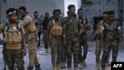 FILE - Police officers stand near the bodies of alleged Al-Shabaab militants who have been killed after the siege at the Mogadishu Municipality Headquaters in Mogadishu on January 22, 2023.