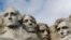 FILE - A raptor flies over Mount Rushmore on March 22, 2019, in Keystone, S.D. From left are former presidents George Washington, Thomas Jefferson, Theodore Roosevelt and Abraham Lincoln.