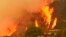 Flames from a back fire rise behind a home in Santa Barbara, Calif. A new red flag warning was scheduled to go into effect Saturday in the fire area because of the predicted return of winds. The Thomas Fire erupted Dec. 4, 2017, a few miles from Thomas Aquinas College.