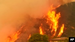 Les flammes se lèvent derrière une maison à Santa Barbara, Californie, 14 décembre 2017.