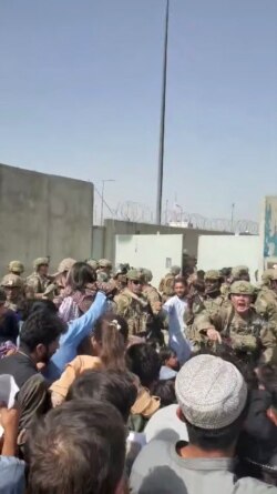 Afghanistan Special Forces try to keep a crowd from entering, outside Kabul Airport, Aug. 18, 2021 in this still image obtained from a social media video.