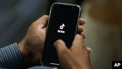 FILE - A man opens social media app TikTok on his cellphone in Islamabad, Pakistan, July 21, 2020.