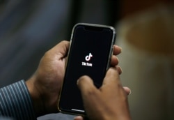 FILE - A man opens social media app TikTok on his cellphone, in Islamabad, Pakistan, July 21, 2020.