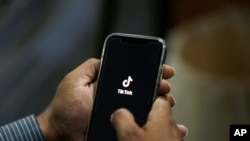 FILE - A man opens social media app TikTok on his cellphone, in Islamabad, Pakistan, July 21, 2020.