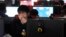 FILE - A man scratches his face as he uses a computer at an internet cafe in Hefei, Anhui province March 16, 2012. Foreign businesses operating in China fear new rules on online publication may mean further curbs, as groups from across politics, business and civil society try to understand the scope of the legislation. 