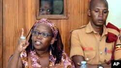 FILE - Makerere University researcher Dr. Stella Nyanzi, left, gestures in the dock at Buganda Road Court in Kampala, Apr. 10, 2017.