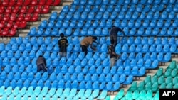 Workers clean pavilion seats on the eve of the International Cricket Council Champions Trophy match between Pakistan and New Zealand at National Stadium in Karachi on Feb. 18, 2025.