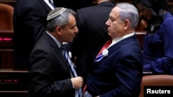 FILE - Israeli Prime Minister Benjamin Netanyahu, right, speaks with member of the Knesset for Likud Zeev Elkin as they attend the swearing-in ceremony of the 22nd Knesset, the Israeli parliament, in Jerusalem, Oct. 3, 2019. 