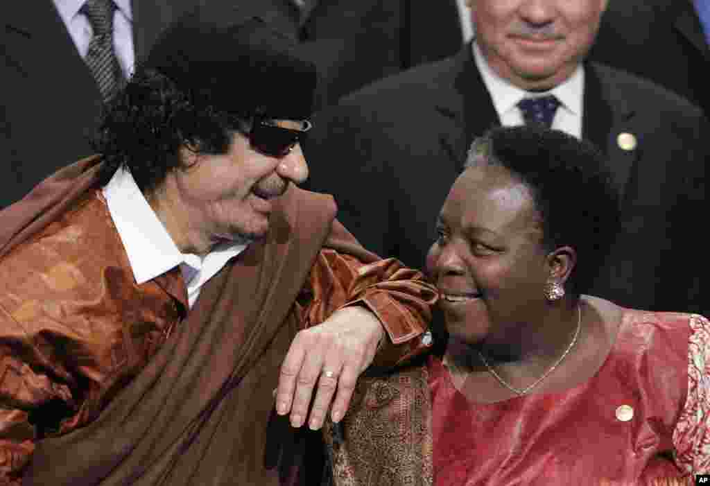 Libyan leader Moammar Gadhafi, left, leans on the shoulder of Pan African Parliament member Gertrude Mongella during a group photo at an EU Africa summit in Lisbon, December 8, 2007. (AP)