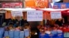 FILE - Handwritten sign with messages that read in Spanish: 'We demand solutions from the government,' 'Arce, don't starve us' and 'Solutions, not more problems' hang from vendors' stalls at a street market in La Paz, Bolivia, Oct. 21, 2024. 