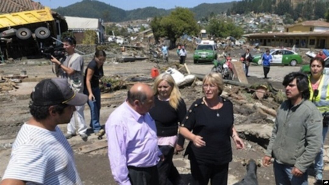 Chile's President Michelle Bachelet (r) talks to residents in a destroyed area of Concepcion, some 100 km (62 miles) south of the epicenter of a huge 8.8-magnitude earthquake that rocked Chile on February 27, 2010.