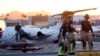 Firefighters work around the site of a crashed Learjet at Scottsdale Airport after it collided with a parked plane Feb. 10, 2025, in Scottsdale, Ariz. 