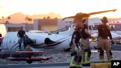 Firefighters work around the site of a crashed Learjet at Scottsdale Airport after it collided with a parked plane Feb. 10, 2025, in Scottsdale, Ariz. 